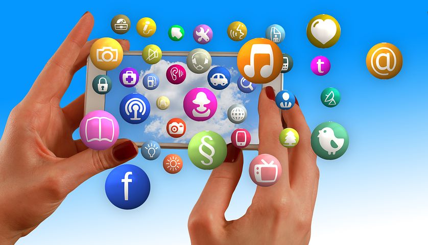 Photo of two hands holding a mobile phone with app icons floating around the image