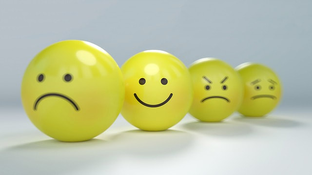 Picture of yellow balls with face expressions drawn on them. Happy face is in focus.