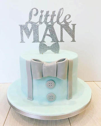 birthday cake with a sign on the top that reads little man