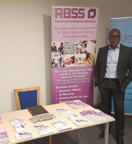 Remi standing by his pop up banner at a networking event