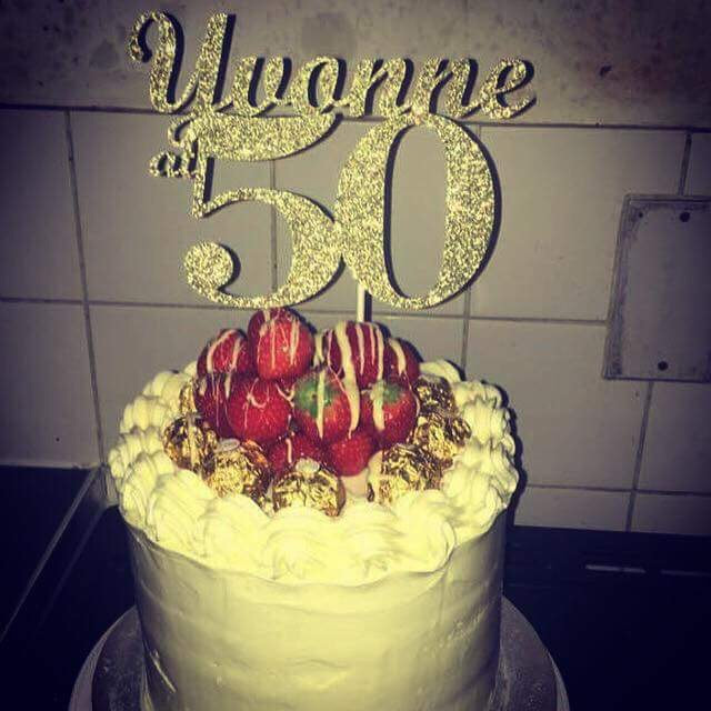 birthday cake with a sign on the top that reads, yvonne at 50