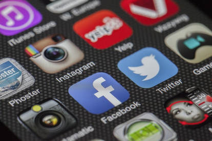 close up of a phone screen showing social media icons like facebook, twitter and instagram